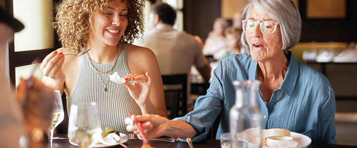 Zwei Frauen an Bord der AIDAcosma probieren asiatische Köstlichkeiten in einem der Restaurants.
